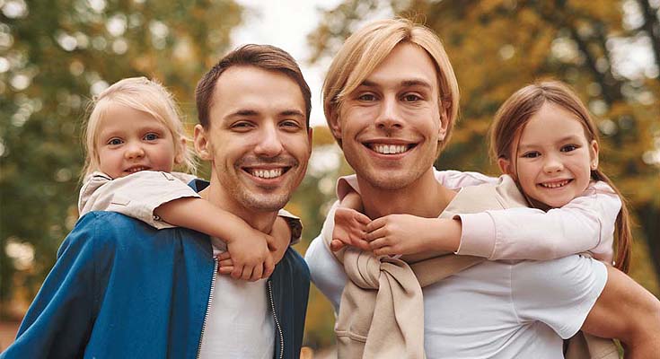 Two men carrying children on their backs